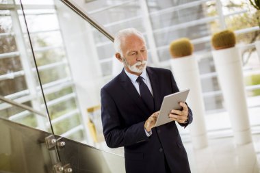 Ofiste dijital tablet kullanarak üst düzey işadamı portresi