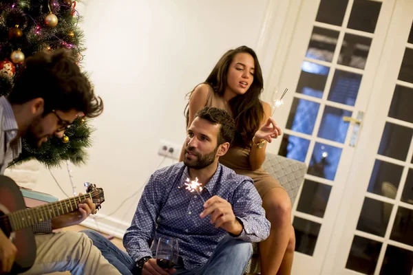 Casal Parabeniza Ano Novo Com Pulverizadores Enquanto Jovem Tocando Guitarra — Fotografia de Stock