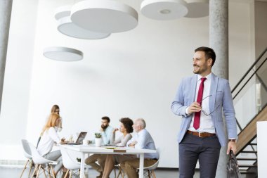 Diğer iş adamları toplantısı sırasında bürosundan çıkarken yakışıklı işadamı