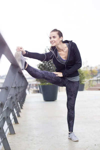 Ganska Ung Kvinna Med Hörlurar Stretching Sport Träning Urban Miljö — Stockfoto