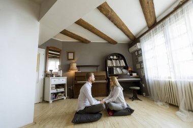 Oda katta oturan mutlu ve sevgi dolu genç çift