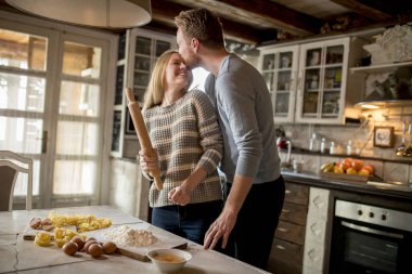 Sevgi dolu çift rustik mutfakta makarna hazırlama