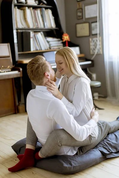 Feliz Amoroso Jovem Casal Beijando Enquanto Sentado Chão Sala — Fotografia de Stock