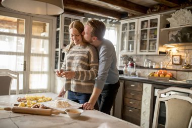 Sevgi dolu çift rustik mutfakta makarna hazırlama