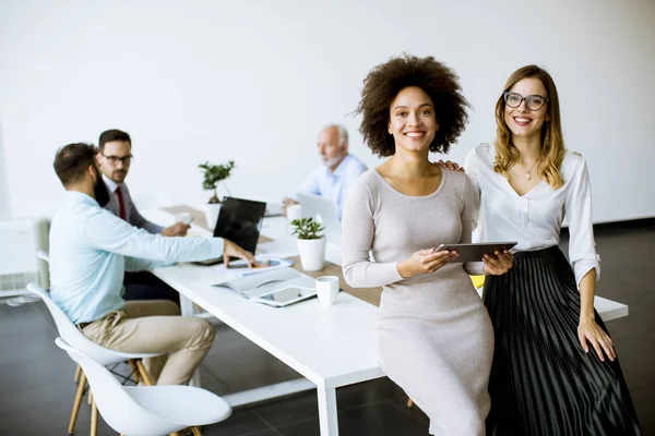 Dos Jóvenes Empresarias Con Una Tableta Oficina Otros Empresarios Que — Foto de Stock