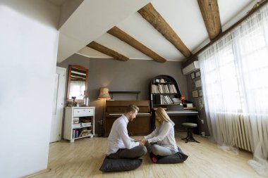 Oda katta oturan mutlu ve sevgi dolu genç çift