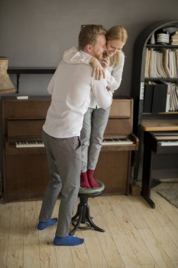 Gülen, kucaklayan ve having fun odaya sevgi dolu genç Çift