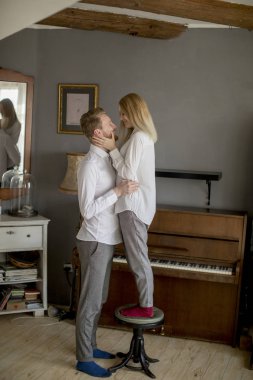 Gülen, kucaklayan ve having fun odaya sevgi dolu genç Çift