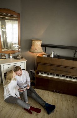 Mutlu ve sevgi dolu genç çift oda katta otururken bir kitap okuma