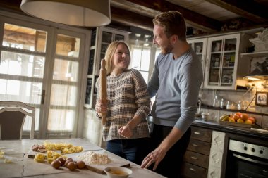 Sevgi dolu çift rustik mutfakta makarna hazırlama