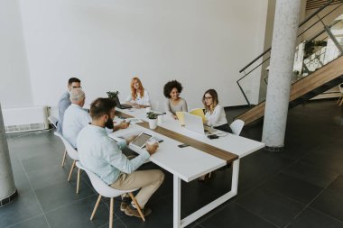 Görünümü çok ırklı iş adamları toplantı ve gülümseyen personel sırasında masa etrafında