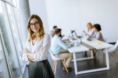 Modern ofiste duran genç oldukça çekici kadın Yöneticisi