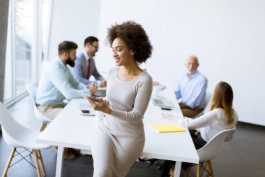 Gülümseyen Afrikalı kadın Office birlikte çalışma diğer iş adamları ise tablet kullanma