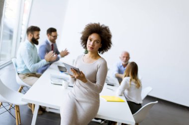 Gülümseyen Afrikalı kadın Office birlikte çalışma diğer iş adamları ise tablet kullanma