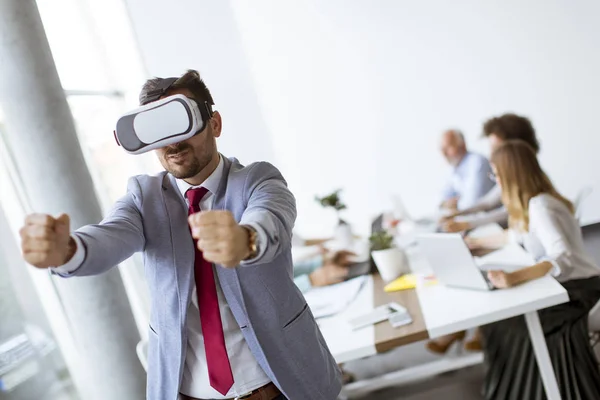 Businessman making team training exercise during team building seminar using VR glasses in office