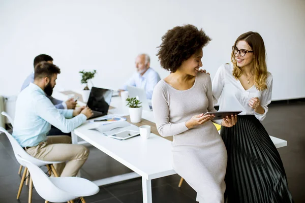 Dos Jóvenes Empresarias Con Una Tableta Oficina Otros Empresarios Que — Foto de Stock