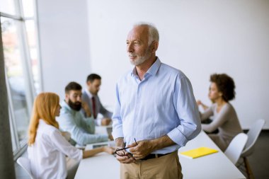 Belgeleri tartışmak ve modern ofisinde çalışan başarılı iş adamları