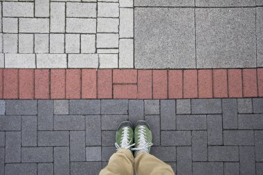 Bir adamın üstten görünüm renkli geometrik kaldırımda duruyor