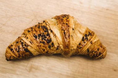 Eski ahşap masa üzerinde lezzetli tereyağı kruvasan adlı görüntüleme