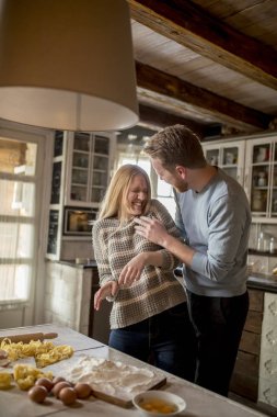 Sevgi dolu çift rustik mutfakta makarna hazırlama
