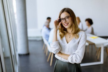 Modern ofiste duran genç oldukça çekici kadın Yöneticisi