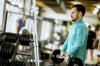 Yakışıklı genç halter salonunda kullanır.