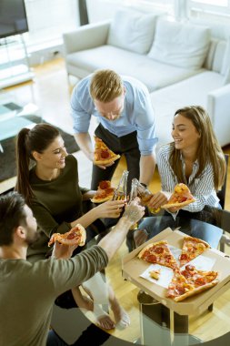 Gençlerin grup pizza yeme ve modern iç elma şarabı içme mutlu
