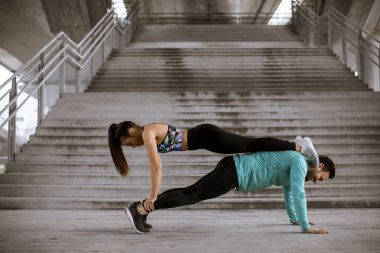 Genç atletik çift açık havada yukarı itin yapıyor