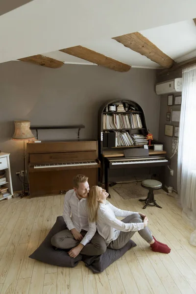 Oda katta oturan mutlu ve sevgi dolu genç çift