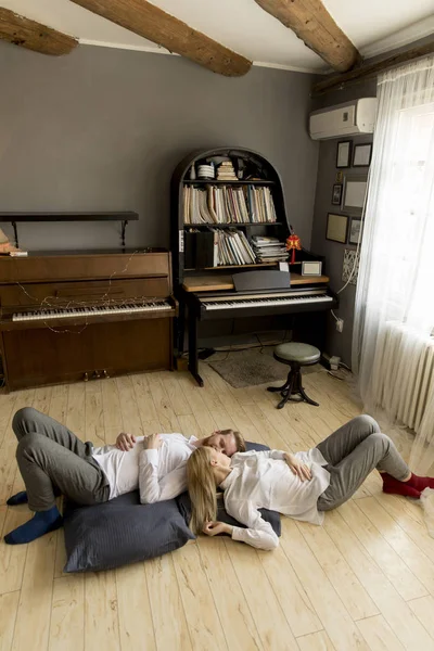 爱年轻夫妇躺在家里 亲吻在地板上 — 图库照片