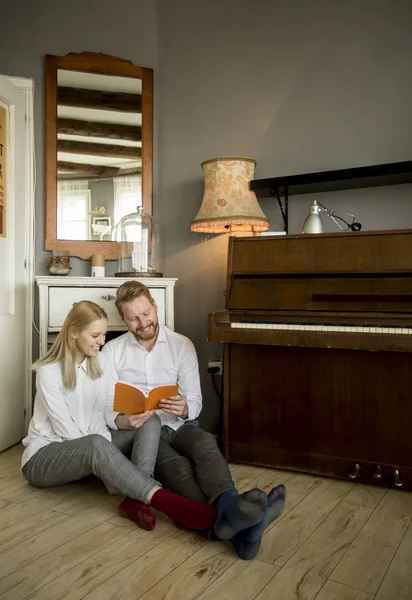 Mutlu ve sevgi dolu genç çift oda katta otururken bir kitap okuma