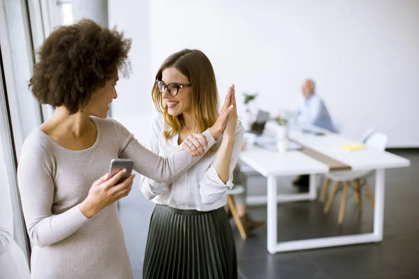 Zwei Junge Geschäftsfrauen Mit Einem Handy Büro Und Andere Geschäftsleute — Stockfoto