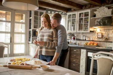 Sevgi dolu çift rustik mutfakta makarna hazırlama