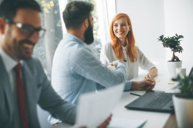 Modern ofisinde çalışan mutlu genç iş adamları