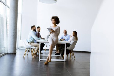 Gülümseyen Afrikalı kadın Office birlikte çalışma diğer iş adamları ise tablet kullanma