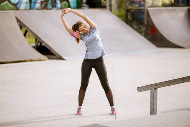 Genç ve güzel kadın parkta germe