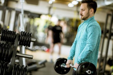 Yakışıklı genç halter salonunda kullanır.