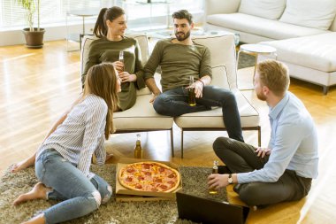 Gençlerin grup pizza yeme ve modern iç elma şarabı içme mutlu