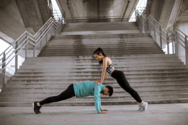 Genç atletik çift açık havada yukarı itin yapıyor