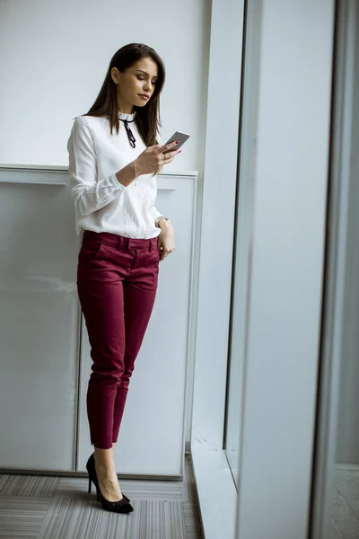 Pengusaha Wanita Muda Yang Berdiri Kantor Dan Menggunakan Ponsel — Stok Foto