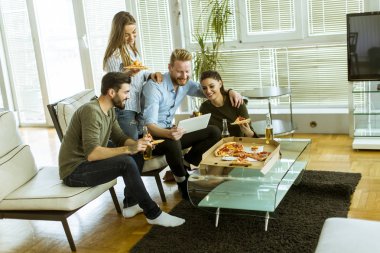 Pizza yemek, elma şarabı içme ve dijital tablet odasında izlerken gençlerin Grup