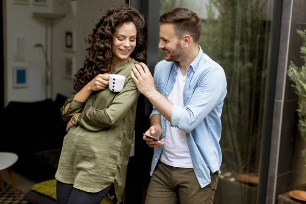 お互いを受け入れ ウィンドウによって自宅でコーヒーを飲む幸せな若いかわいいカップル — ストック写真