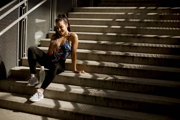 Młody Sportowy Kobieta Odpoczynku Słuchać Muzyki Telefonie Treningu Odkryty Środowisko — Zdjęcie stockowe