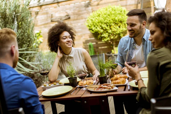 Cheerful young people have lunch in the courtyard and have fun