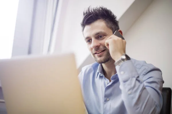 Ung Och Stilig Affärsman Med Mobiltelefon Och Arbetar Bärbar Dator — Stockfoto