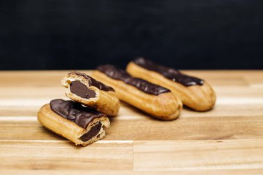 Pasta gevrek kremalı pasta üzerinde ahşap arka plan izole koyu çikolata ile