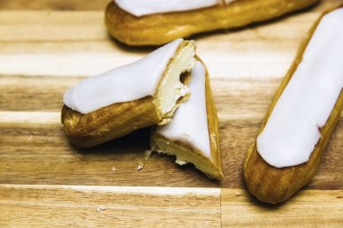 Ahşap arka plan üzerinde izole eclair gevrek kremalı pasta beyaz çikolata ile