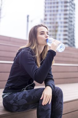 Genç kadın egzersiz ve içecek su açık sonra yenileniyor