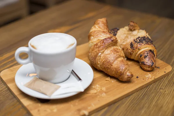 ホット コーヒーとクロワッサンおいしいヴィンテージ テーブル上に配置のカップで伝統的なフランスの朝食で表示します — ストック写真