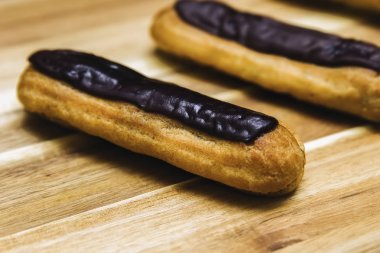 Pasta gevrek kremalı pasta üzerinde ahşap arka plan izole koyu çikolata ile